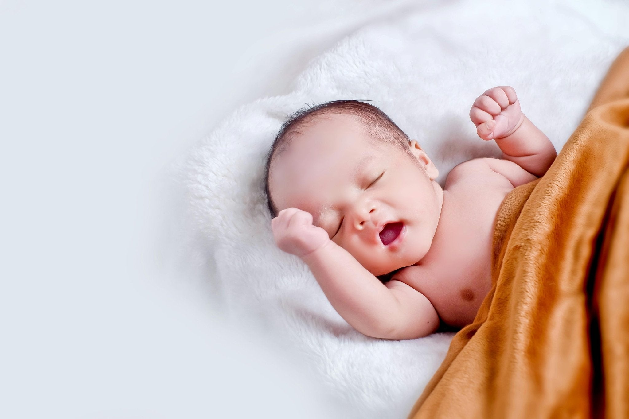 Newborn baby wrapped in a soft blanket, symbolising gentle and safe baby care products.