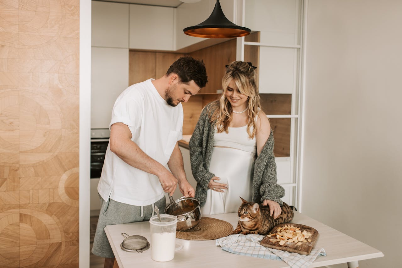 Expecting couple preparing a healthy meal in the kitchen, symbolising the importance of nutrient-rich foods during pregnancy