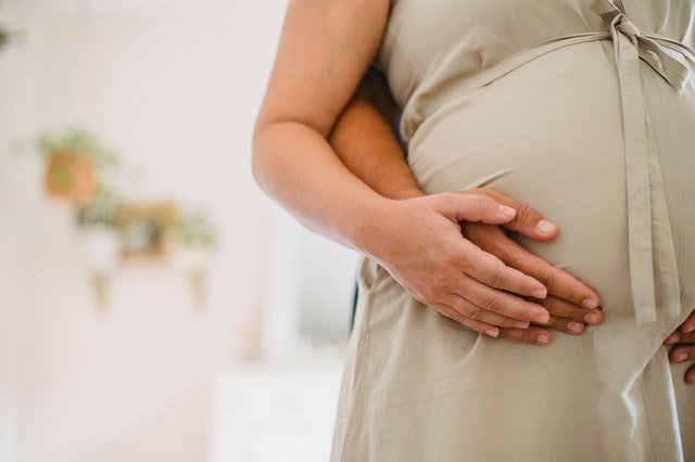 Pregnant woman holding her belly, symbolising the role of collagen and glycine in supporting maternal health, skin elasticity, and recovery.